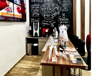 Cantinho do café aconchegante na recepção preparado para oferecer conforto aos pais durante a espera.