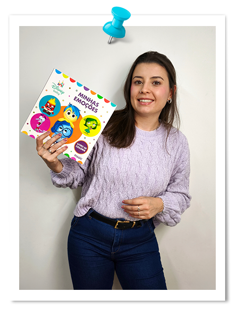Especialista em TDAH e ansiedade infantil sorrindo e segurando o livro Minhas Emoções.